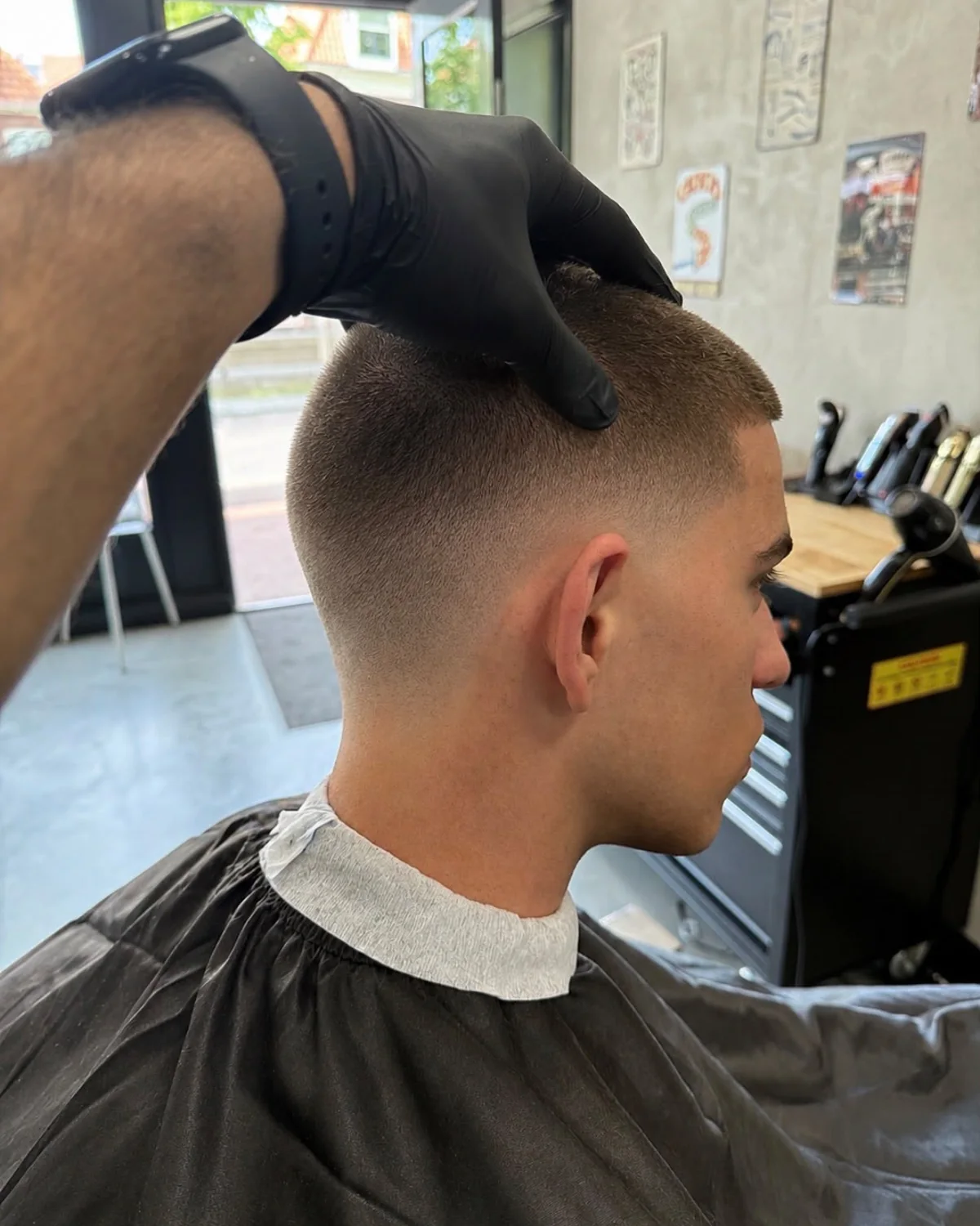 Strak opgeschoren kort herenkapsel met een vloeiende low fade bij Berkay's Barbershop in Hoorn