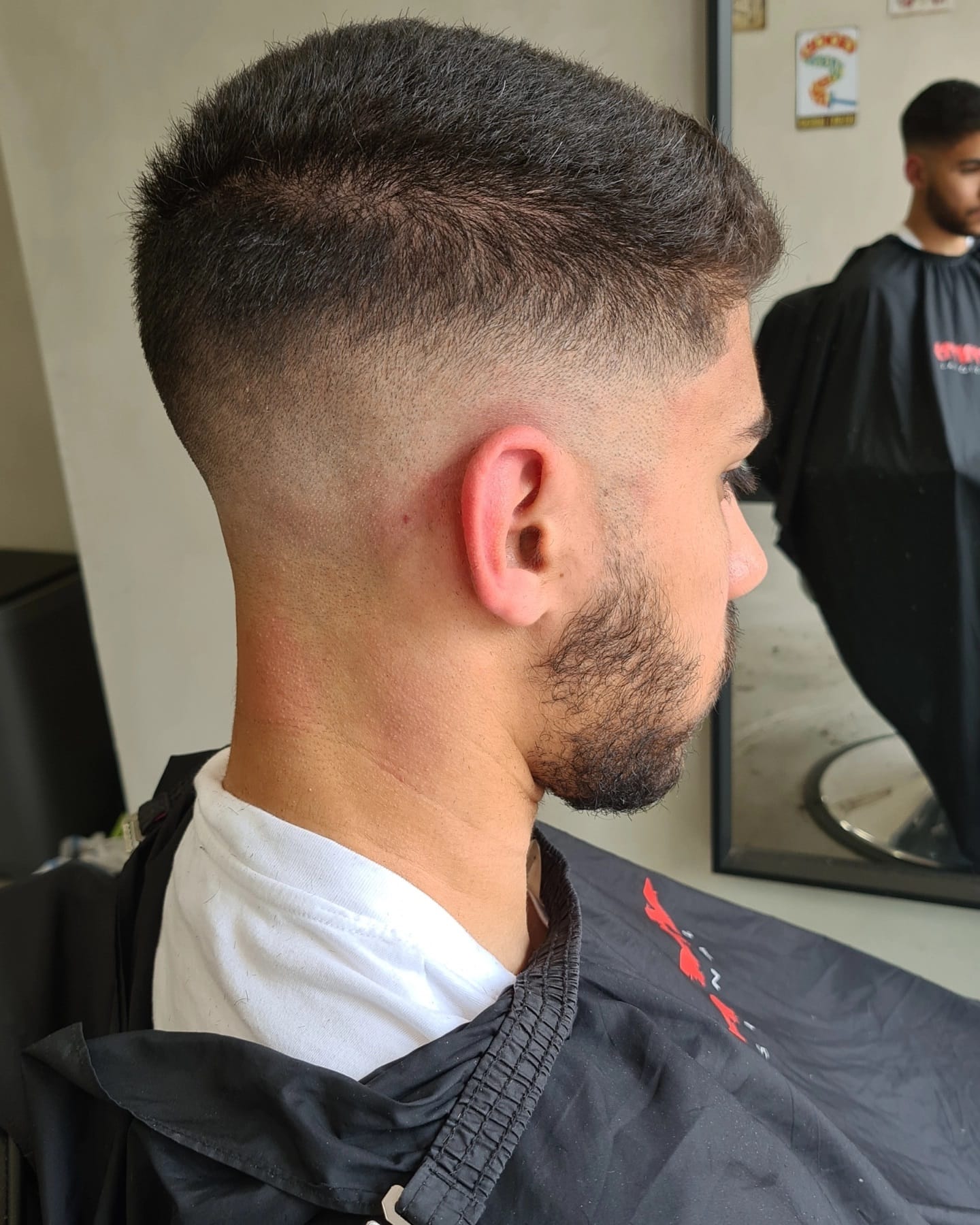 Donker cropkapsel met high fade en een scherp afgelijnde baard