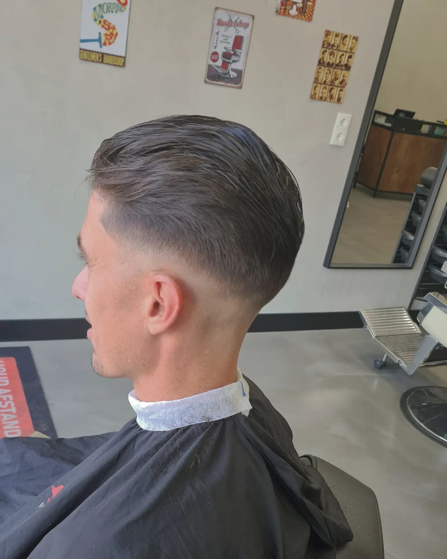 Lang haar strak achterover gekamd met een nette low fade