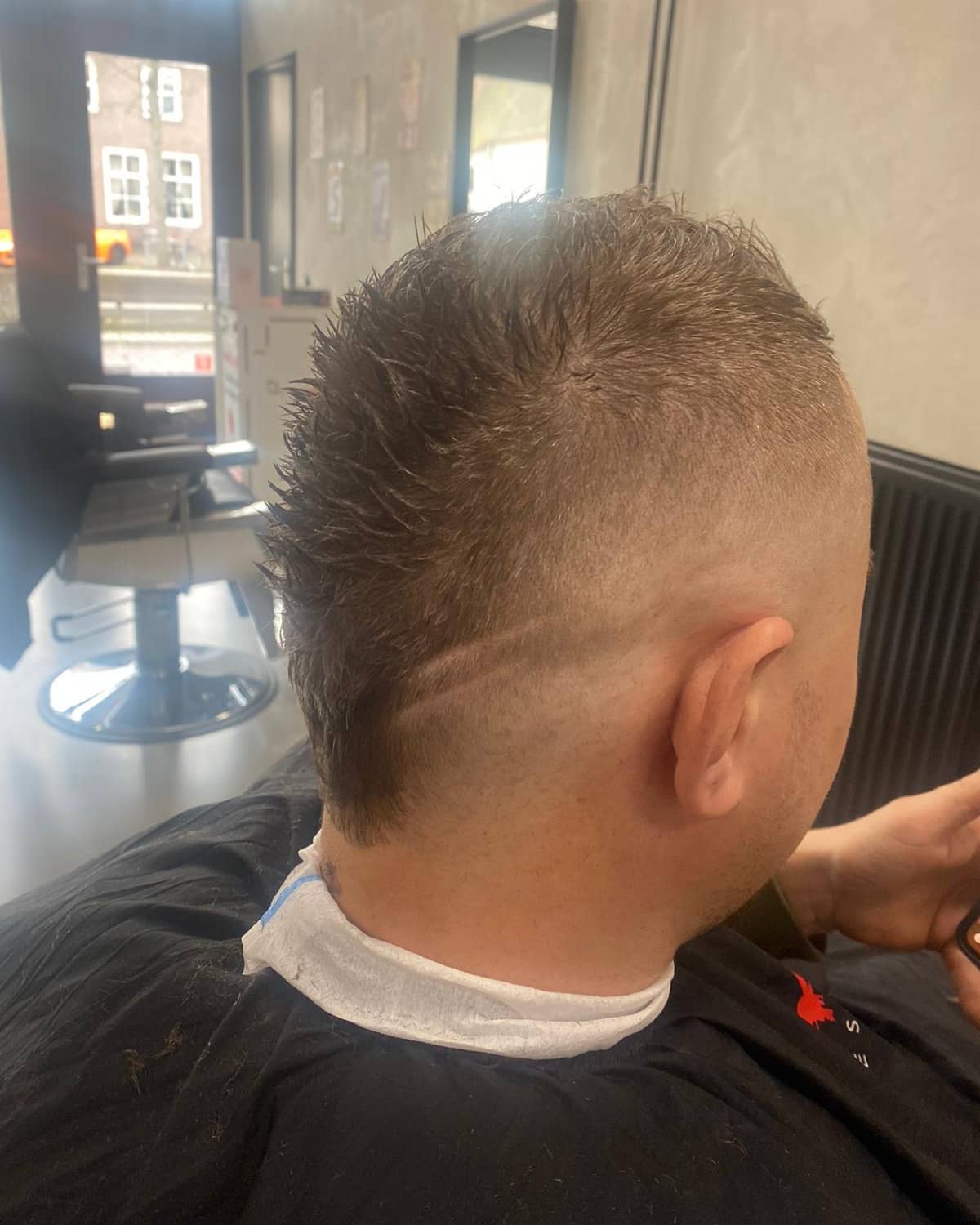 Kort stekelig herenkapsel met taps afgewerkte nek en zijkanten