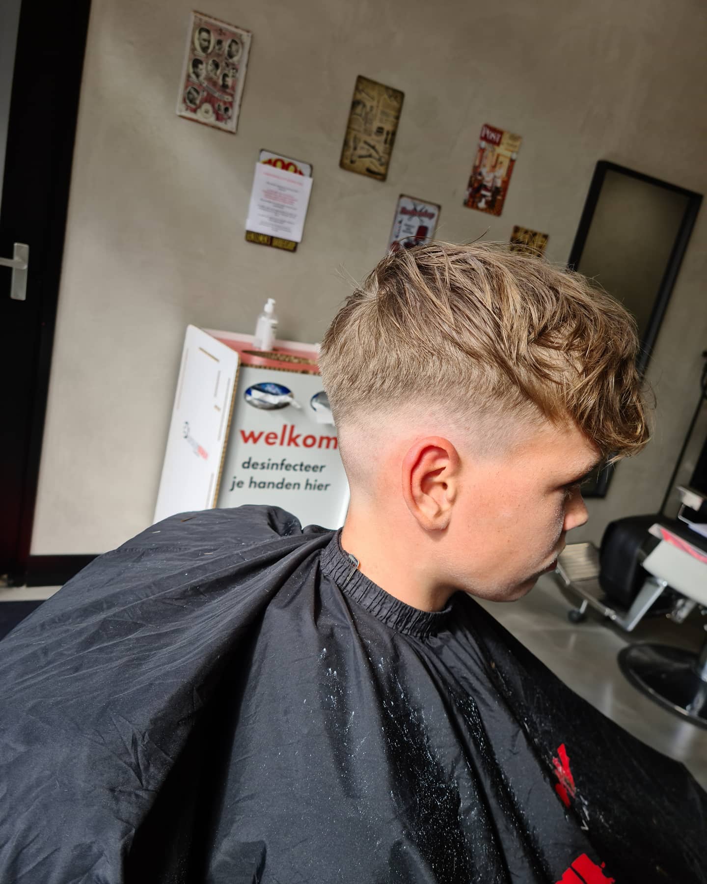 Blond rommelig cropkapsel met textuur en een zachte low fade
