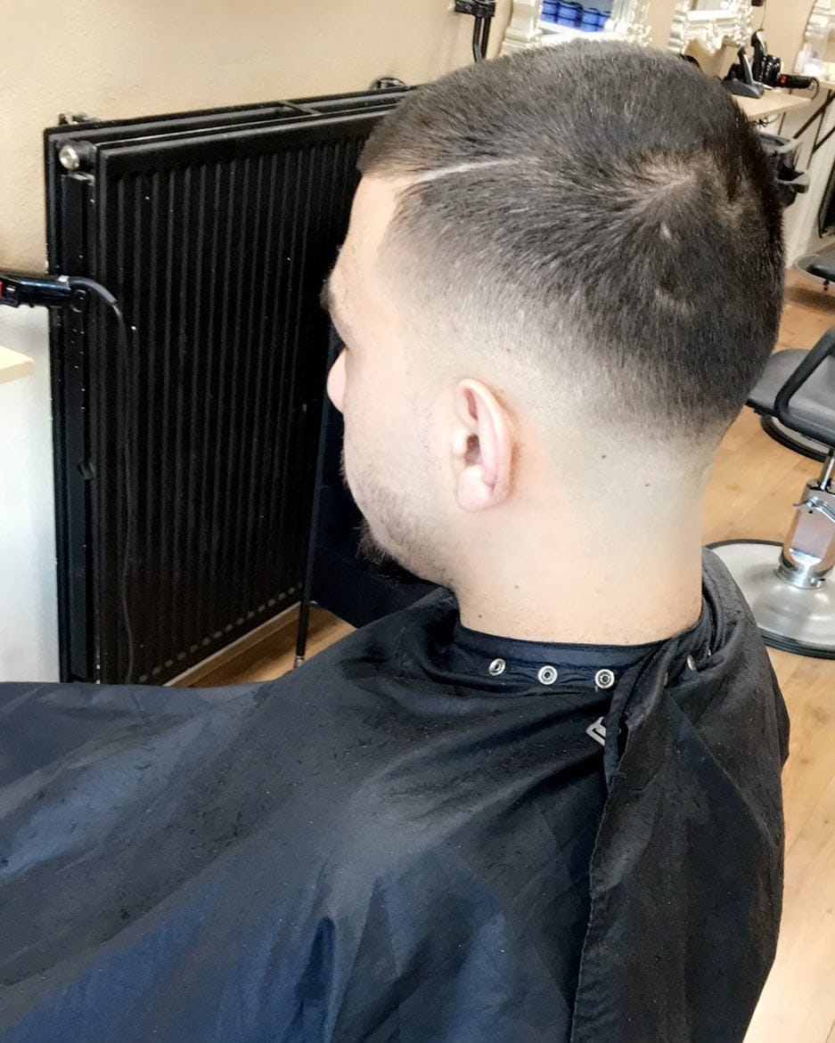 Achteraanzicht van een kort herenkapsel met een vloeiende high fade